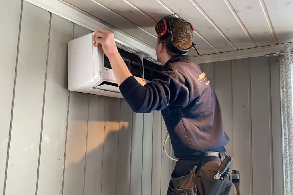 a man working on a air conditioner