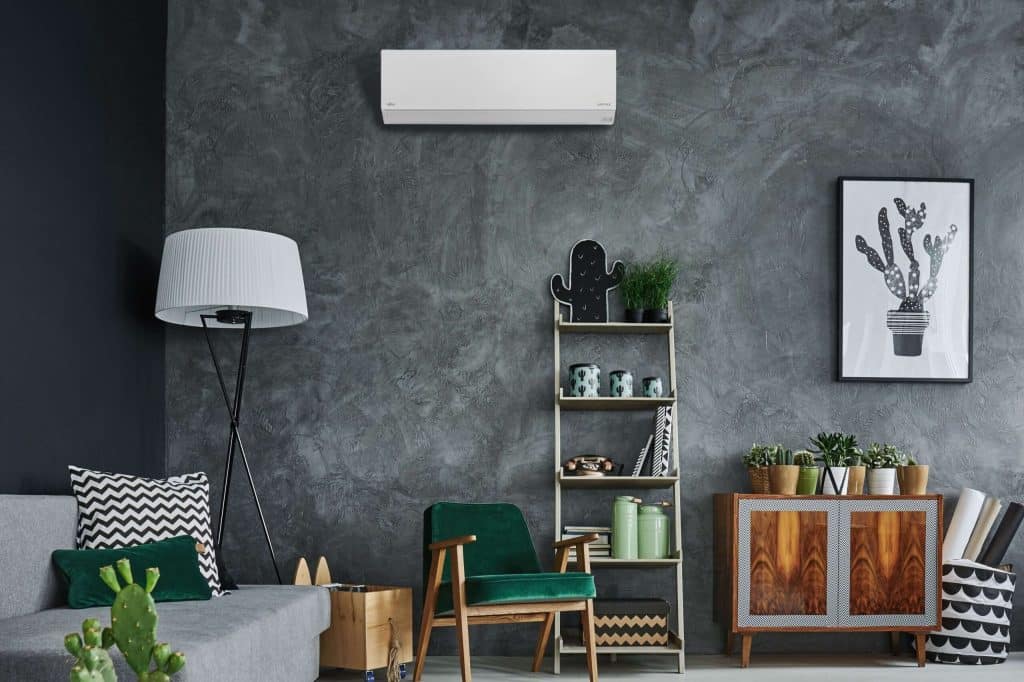 a room with a couch and a bookcase and a lamp